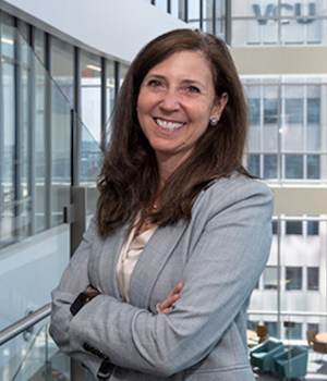 Woman stands in front of hospital background
