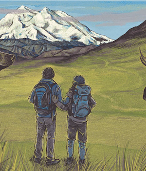 Two men stand facing away towards a tall snow covered mountain